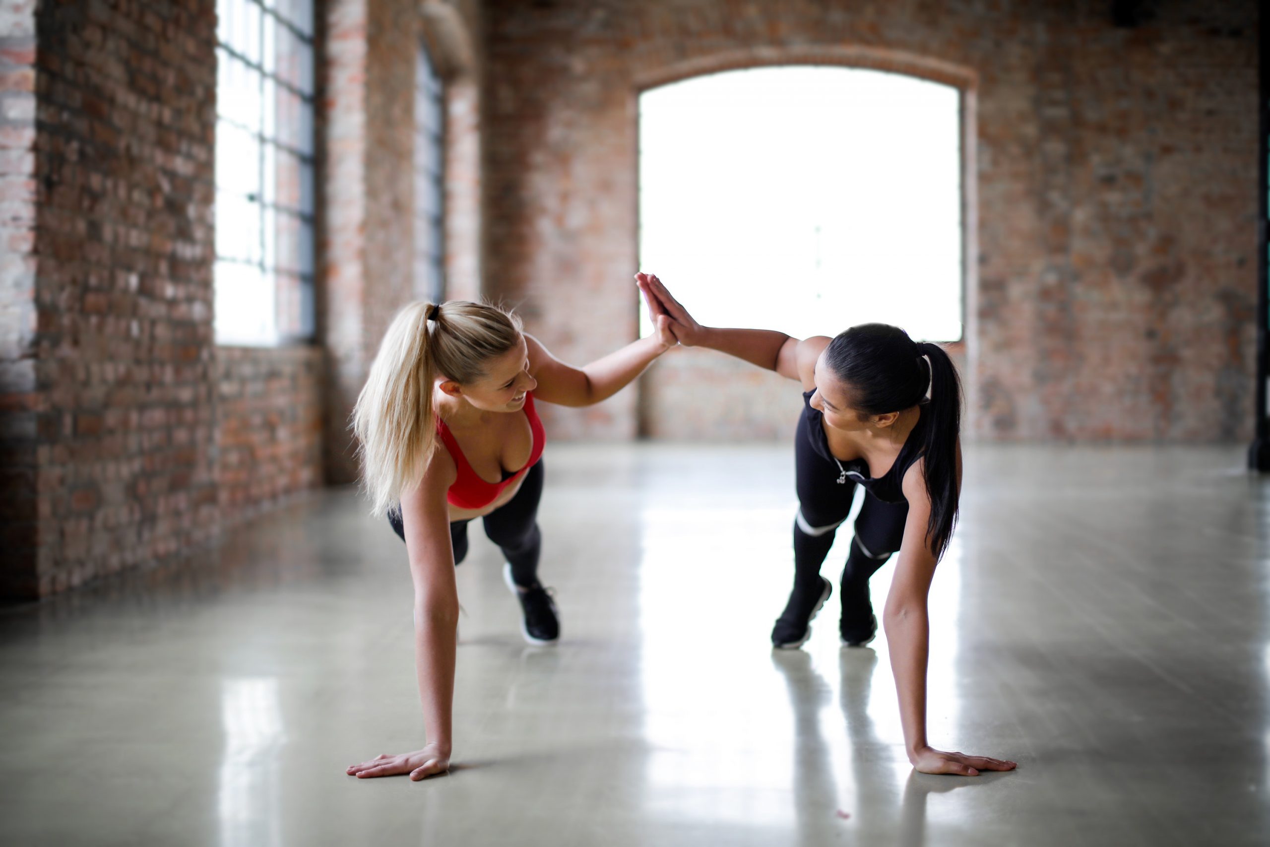 En la foto, dos mujeres haciendo ejercicios pliométricos. /Pexels