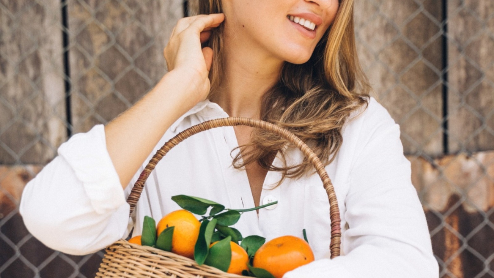Chica con cesta de naranjas