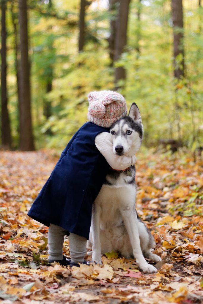 Una niña abrazando a su perro