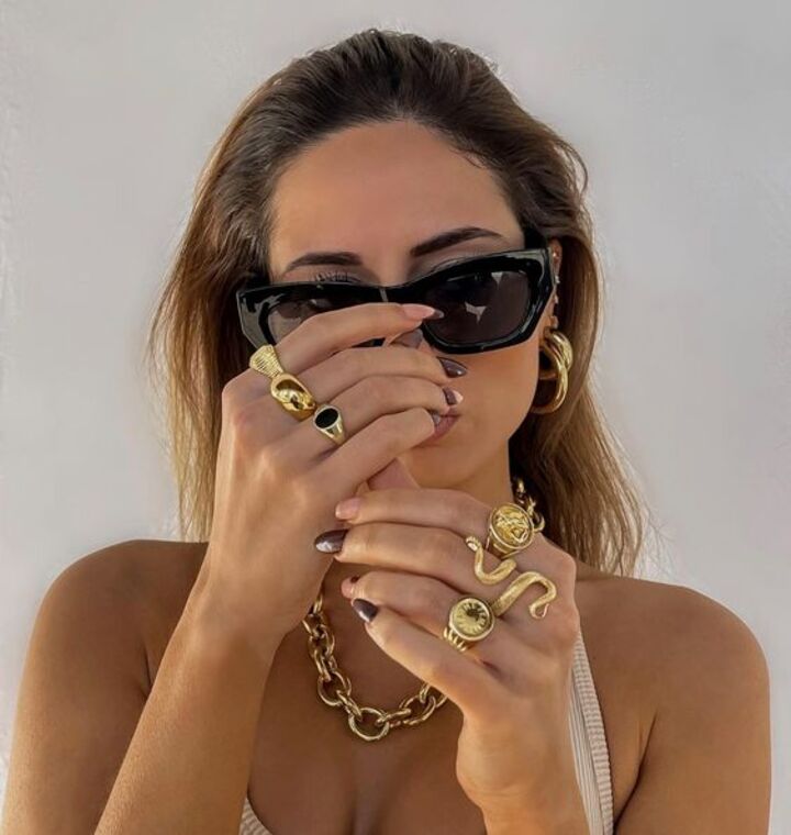 Mujer con combinación de anillos de oro