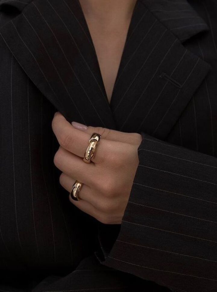 Mujer anillos de oro, blazer negro