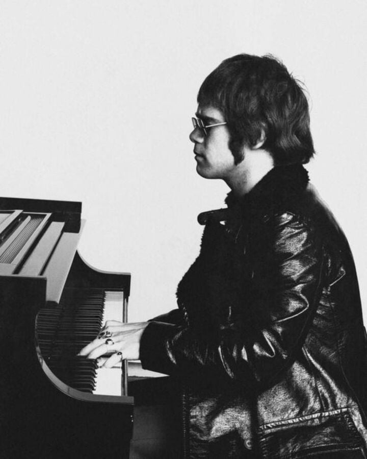 Elton John con piano, blanco y negro