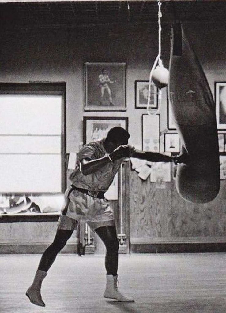 Hombre peleando, saco de boxeo