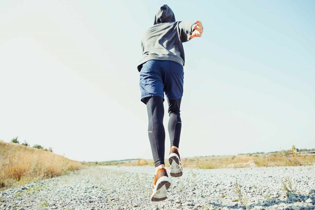 Persona corriendo por el campo con calzado runner