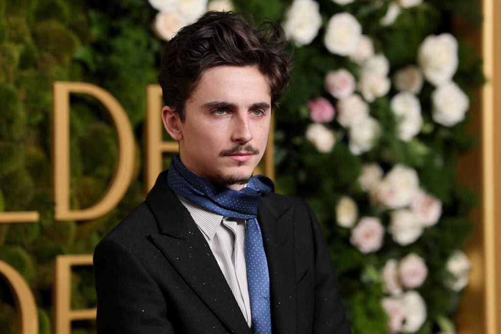 Timothée Chalamet posando serio en los Globos de Oro 2025