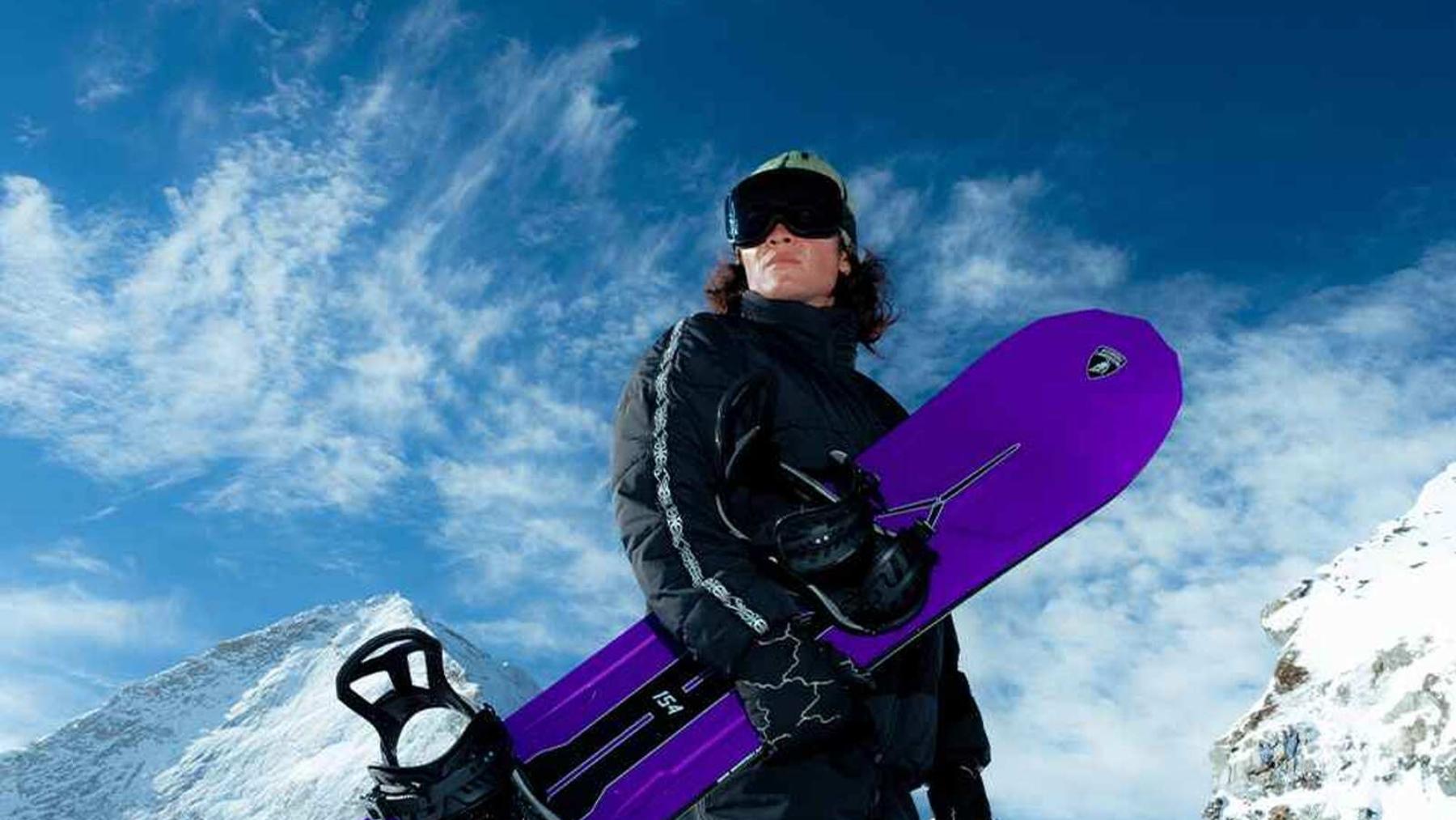 Mujer con la tabla de snowboard morada