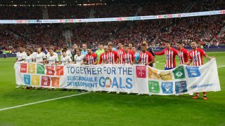 Los jugadores de Atlético y Real Madrid posan con la pancarta de Agenda 2030. (EFE)