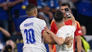Kylian Mbappé, con su camiseta de Francia junto a un espontáneo. (Getty)