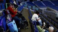 Ciudadanos descansando en el Movistar Arena. (EFE)