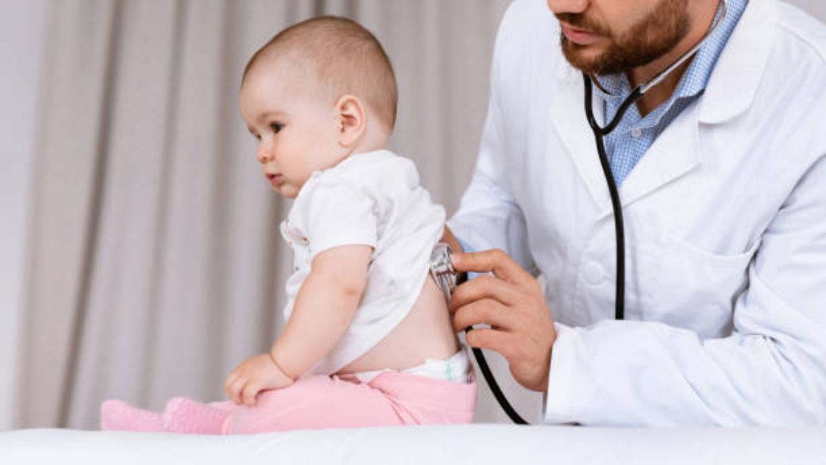 Un médico ausculta a un niño sobre una bronquiolitis.