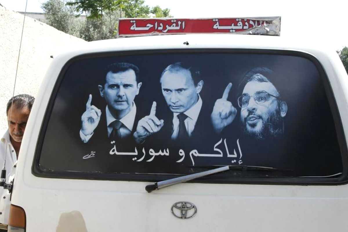 Un cartel que muestra al presidente sirio, Bashar el Asad (I), al ruso, Vladimir Putin, y al líder de Hezbolá, Sayed Hasan Nasralá en un microbus en al-Qardahah, cerca de Latakia. (REUTERS/Khaled al-Hariri)