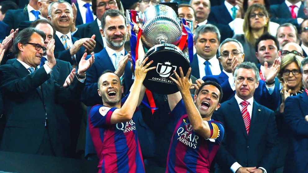 Iniesta y Xavi Hernández levantan la Copa del Rey con el Rey Felipe VI de fondo. (Getty)