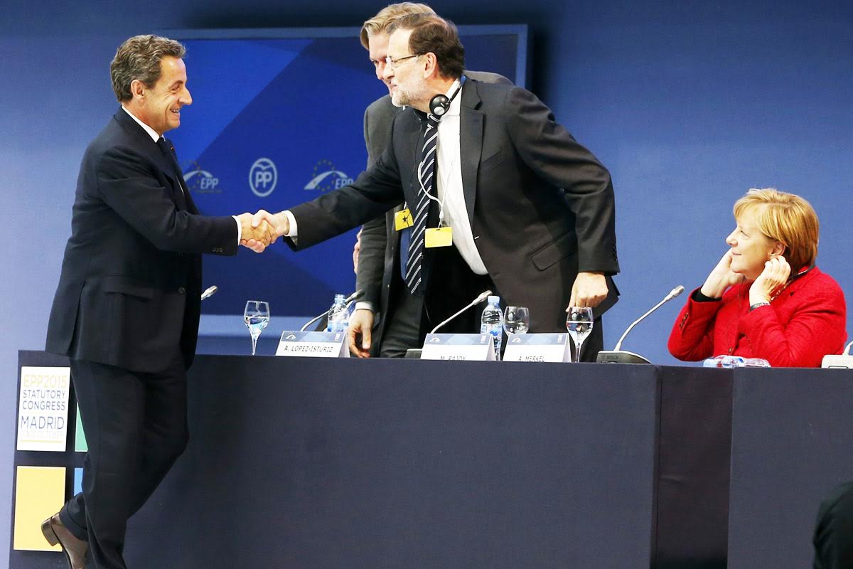 Nicolas Sarkozy saludando a Mariano Rajoy y Angela Merkel en el congreso del PPE. (Foto: EFE)
