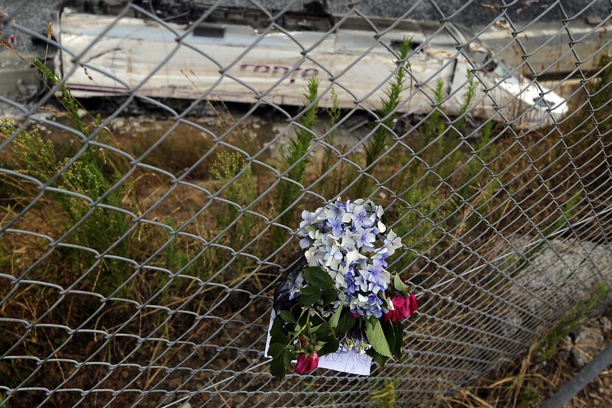 Un ramo de flores ante al máquina accidentada del Alvia en Angrois. (Foto: AFP)