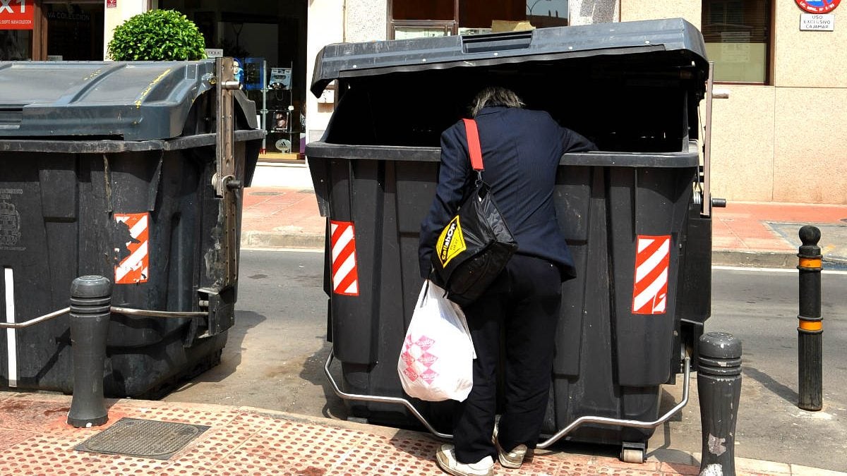 Un hombre busca comida en un contenedor de basura.Foto: Getty