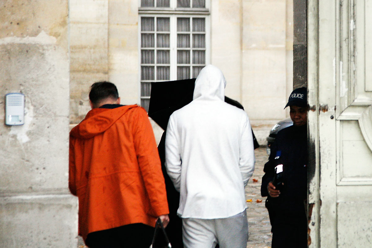 Benzema, con capucha blanca, entrando en comisaría a declarar (Foto: AFP)