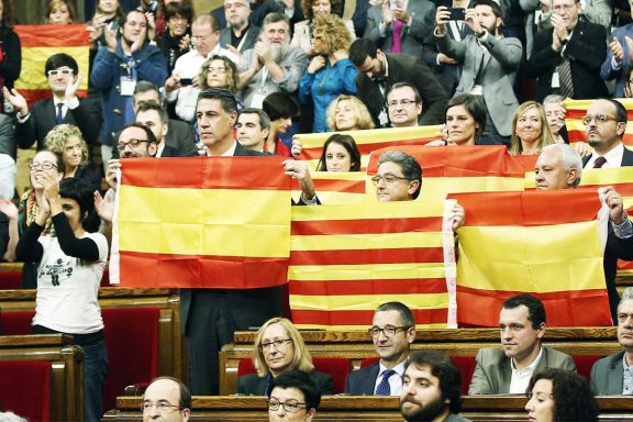 Los parlamentarios del PPC muestran banderas de España y Cataluña tras aprobarse la resolución.