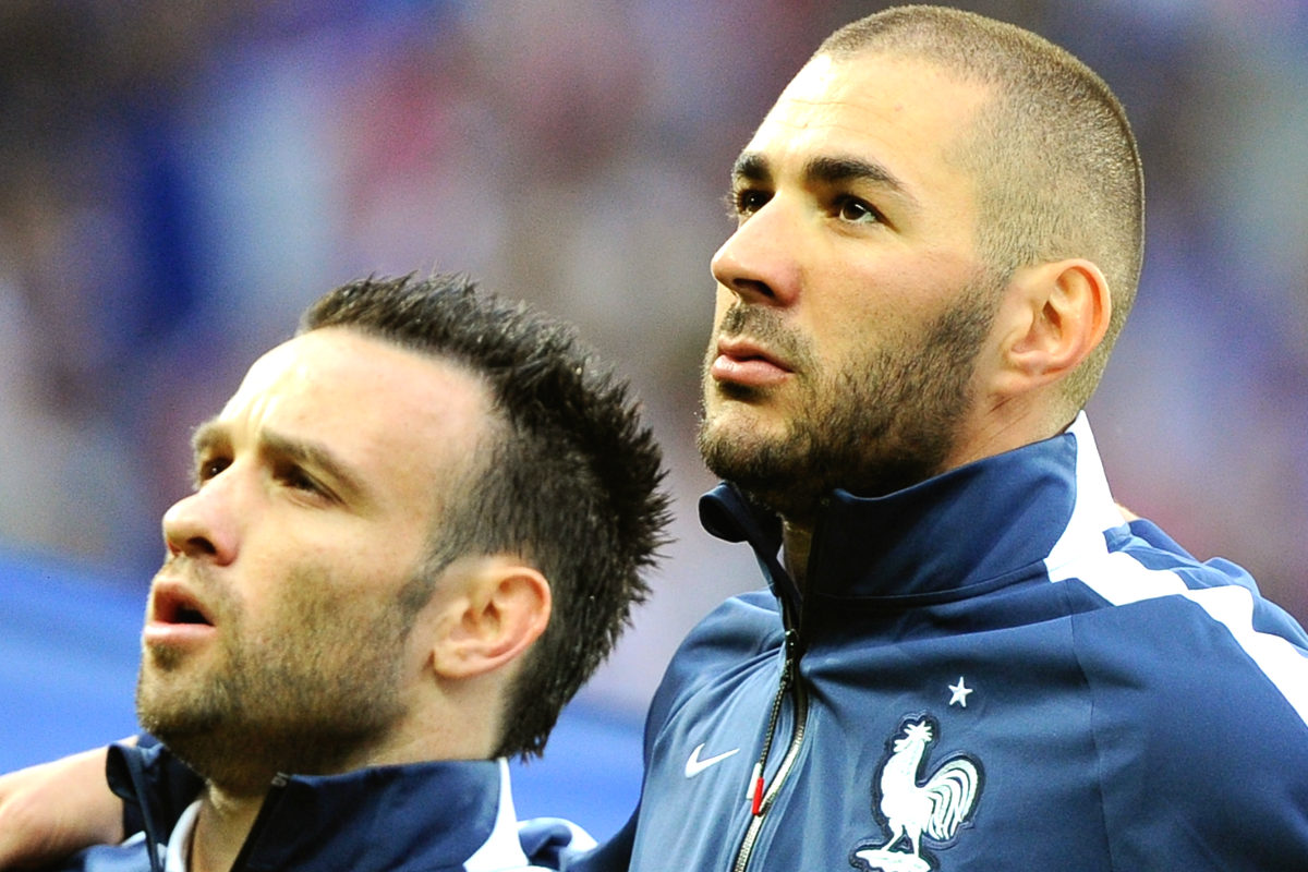 Benzema y Valbuena escuchan abrazados La Marsellesa en un partido de Francia. (AFP)