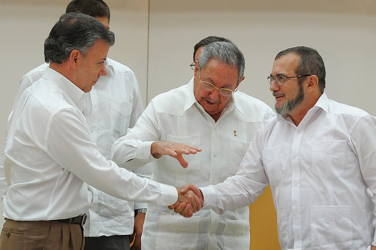 Momento en que Santos y Timochenko escenifican el acuerdo para la paz en Colombia de la mano del dictador cubano,Raúl Castro. (Foto: AFP)