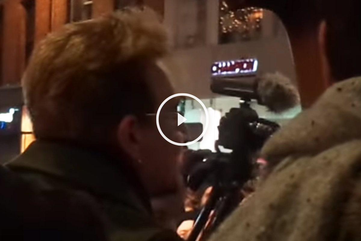 Bono canta en las calles de Dublín ante la fascinación de los transeúntes.