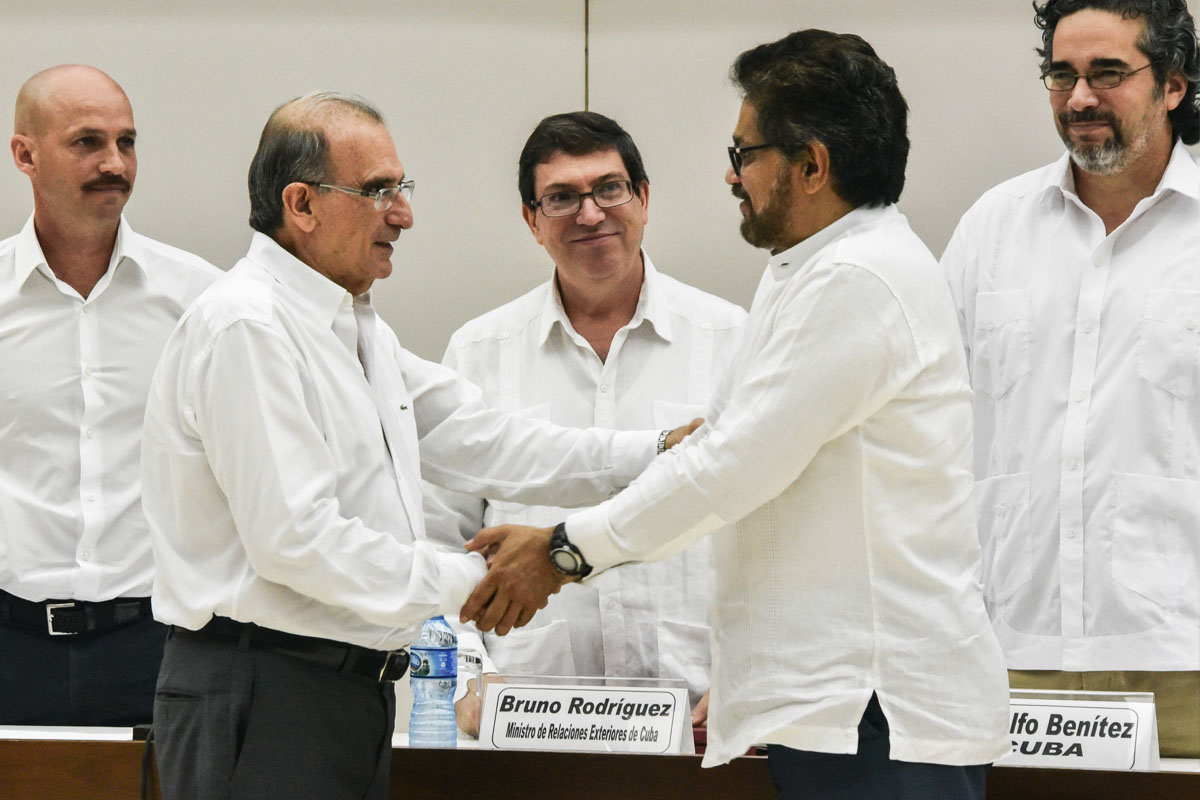 Los emisarios del Gobierno de Colombia y las FARC se estrechan la mano. (Foto: AFP)