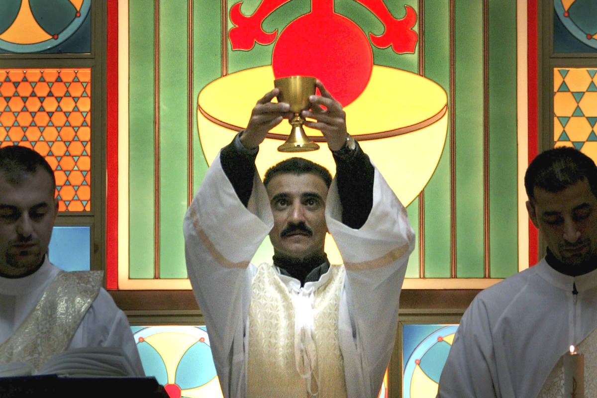 Consagración del vino en una iglesia iraquí (Foto: GETTY).