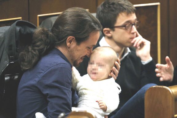 El líder de Podemos, Pablo Iglesias, con la hija de la diputada de su partido Carolina Bescansa en sus brazos en su escaño del Congreso. (Foto:EFE)