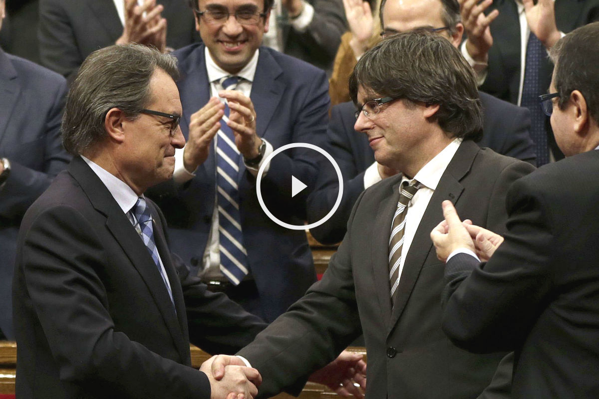 El expresidente de la Generalitat en funciones, Artur Mas (i), felicita a su sucesor, Carles Puigdemont, tras ser elegido nuevo presidente catalán durante el pleno de investidura celebrado en el Parlament de cataluña (Foto: Efe)