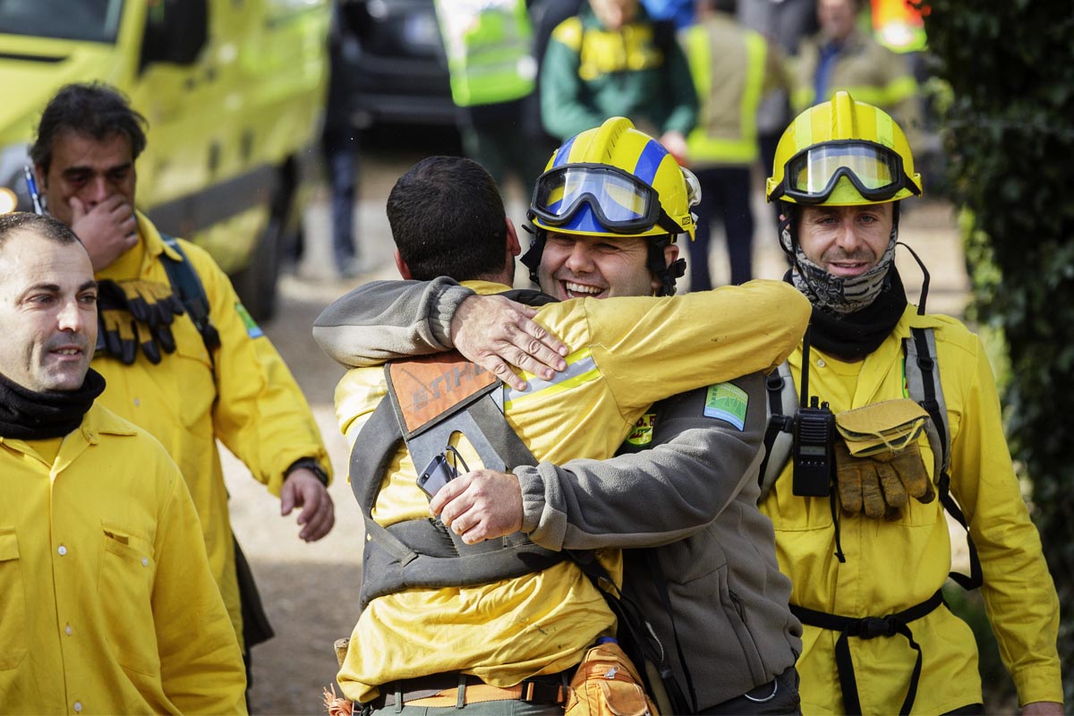 Dos miembros de los equipos de rescate se felicitan tras haber encontrado sano y salvo al niño desaparecido en Gerona. (Foto: EFE)