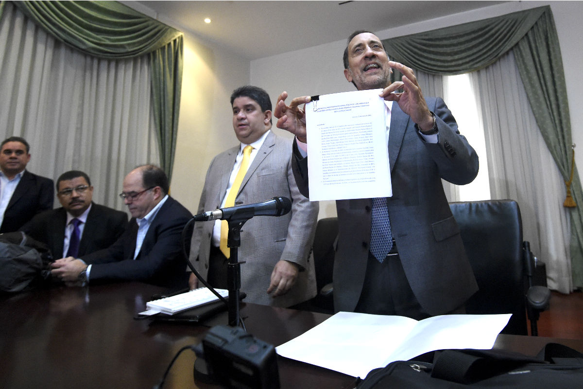 El diputado opositor José Guerra muestra el documento de rechazo (Foto: AFP).