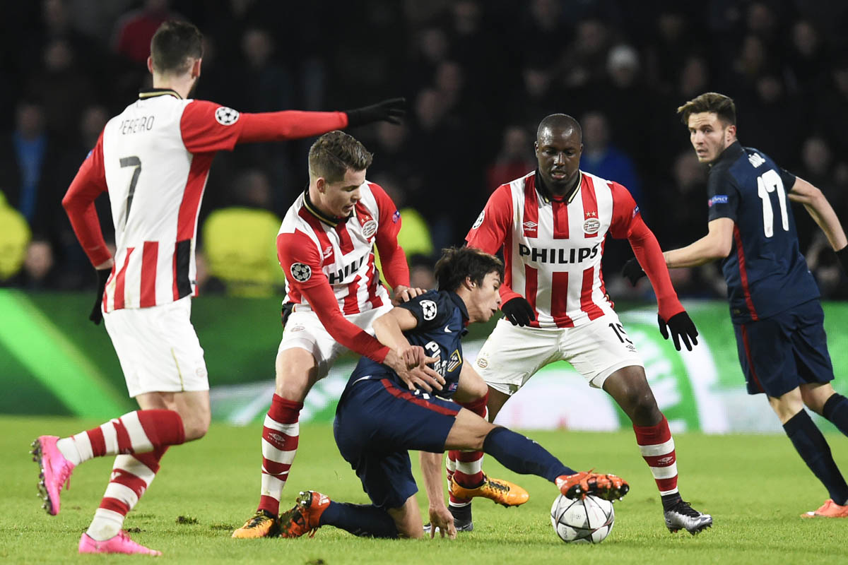 Óliver Torres controla el balón rodeado de futbolistas del PSV. (AFP)
