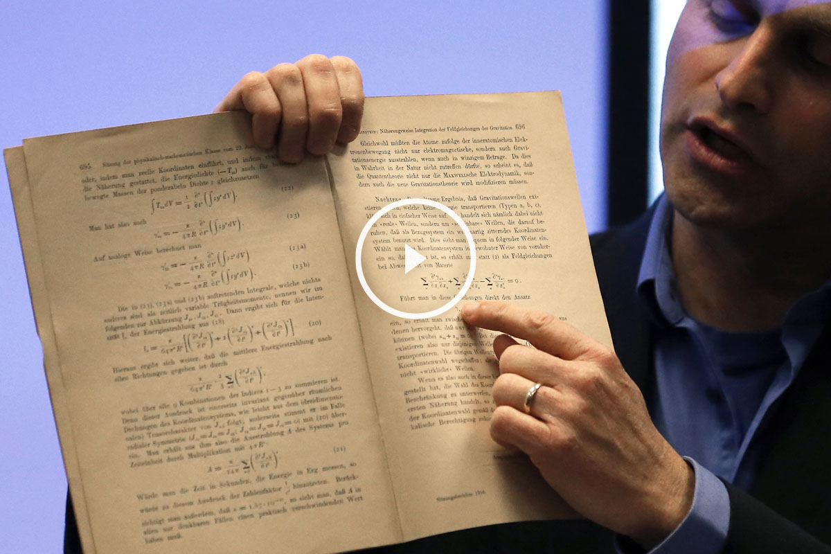 El profesor israelí Barak Kol enseña el documento original donde Einstein explica el fenómeno. (Foto: AFP)