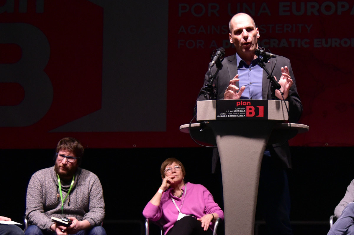 Miguel Urbán (izqda.), atiende el discurso de Varoufakis. (AFP)