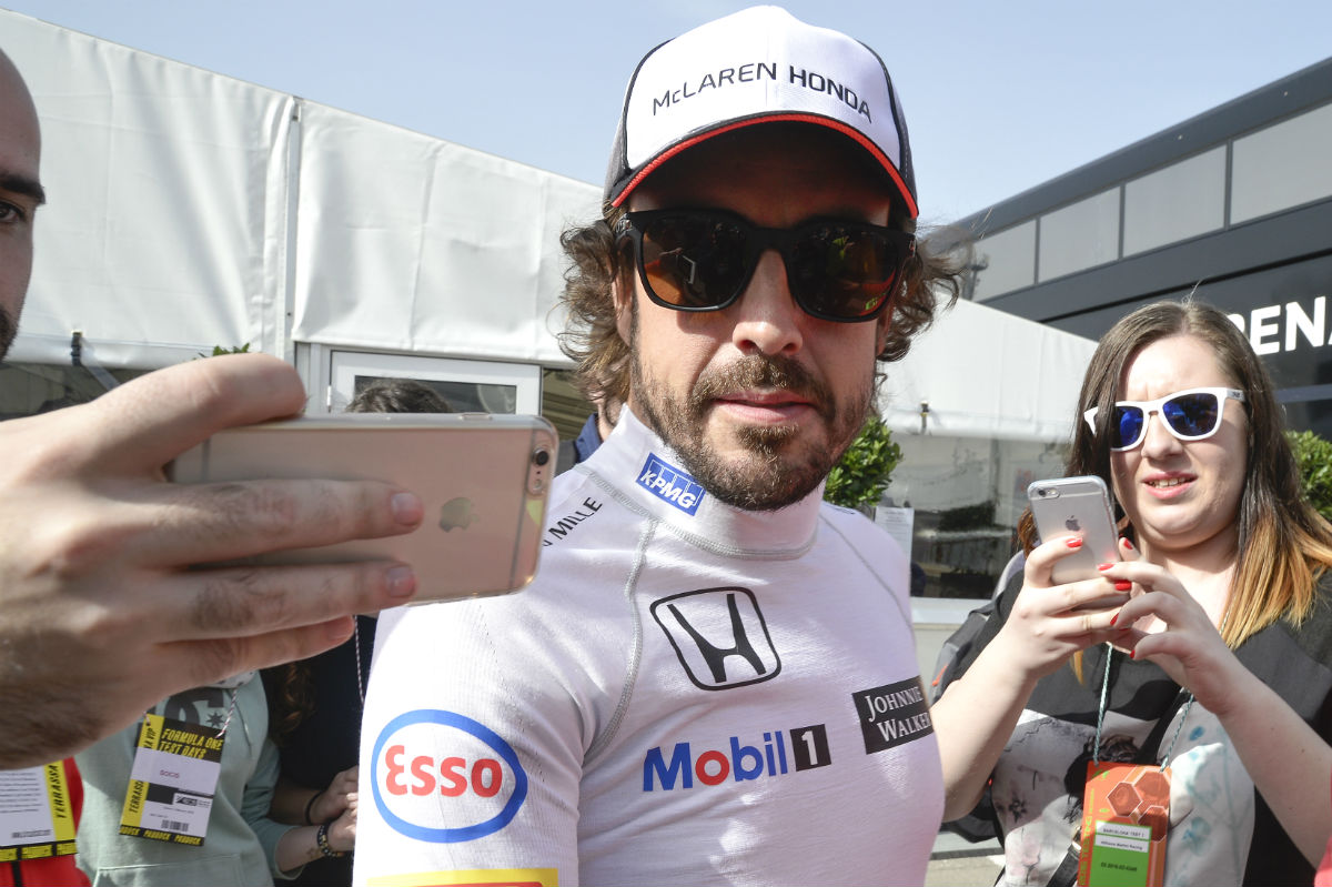 Fernando Alonso se fotografía junto a unos fans. (AFP)
