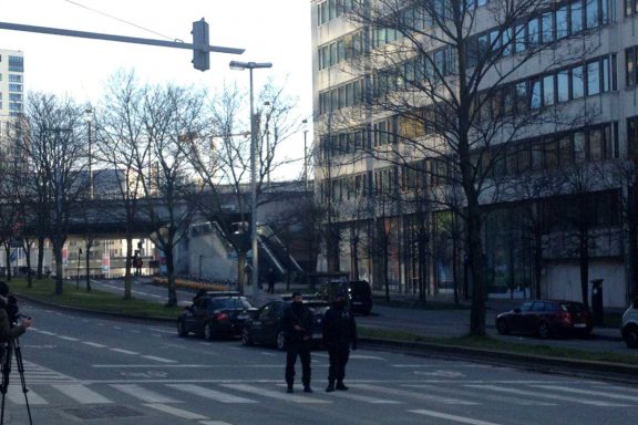 A lo lejos, debajo del puente, una de las tres entradas a la estación de metro de Maelbeek, ahora custodiada por la policía. (Foto: OKDiario)