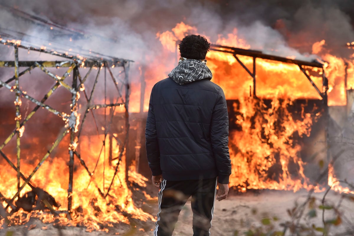 Un migrante observa cómo arde el campamento. (Foto: AFP)