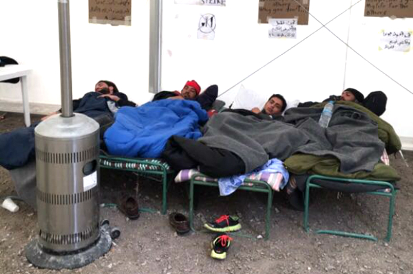 Tres refugiados intentan descansar en el campamento de Gizona.