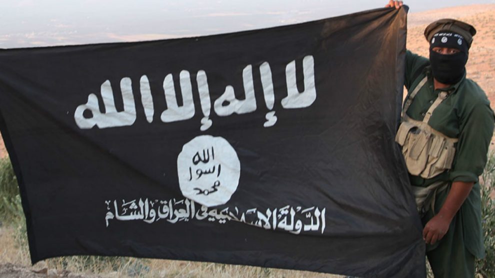 Un yihadista sujeta la bandera del Estado Islámico.
