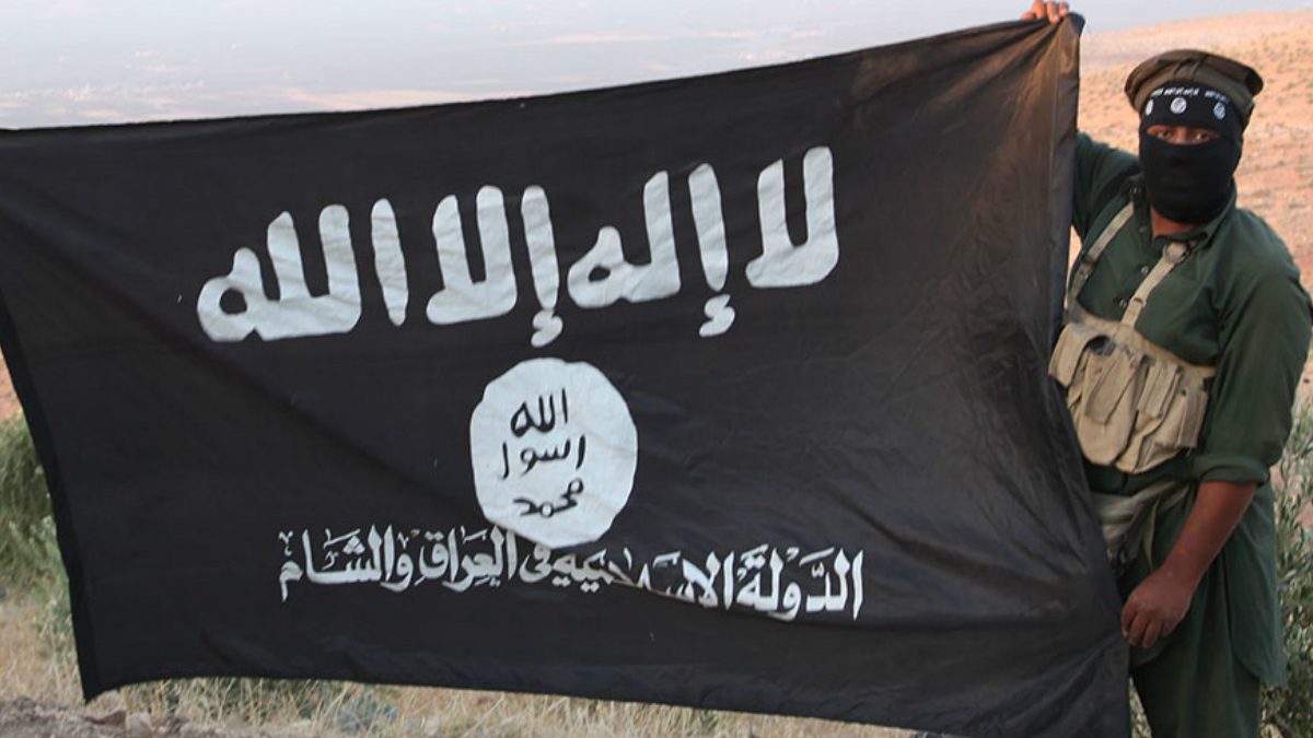 Un yihadista sujeta la bandera del Estado Islámico.