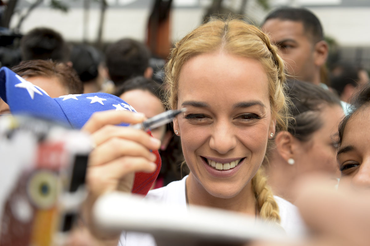 Lilian Tintori, boli en mano para firmar contra Maduro. (Foto: AFP)