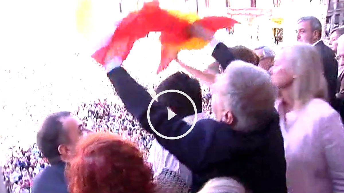 Un concejal del PP desplega la bandera española en el balcón del Ayuntamiento de Barcelona.