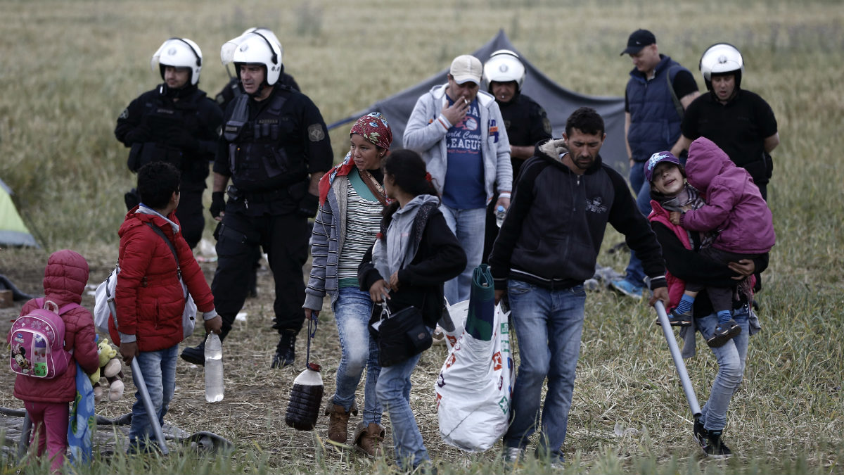 Agentes de la policía griega desalojan a una familia del campo irregular de refugiados de Idomeni. (AFP)