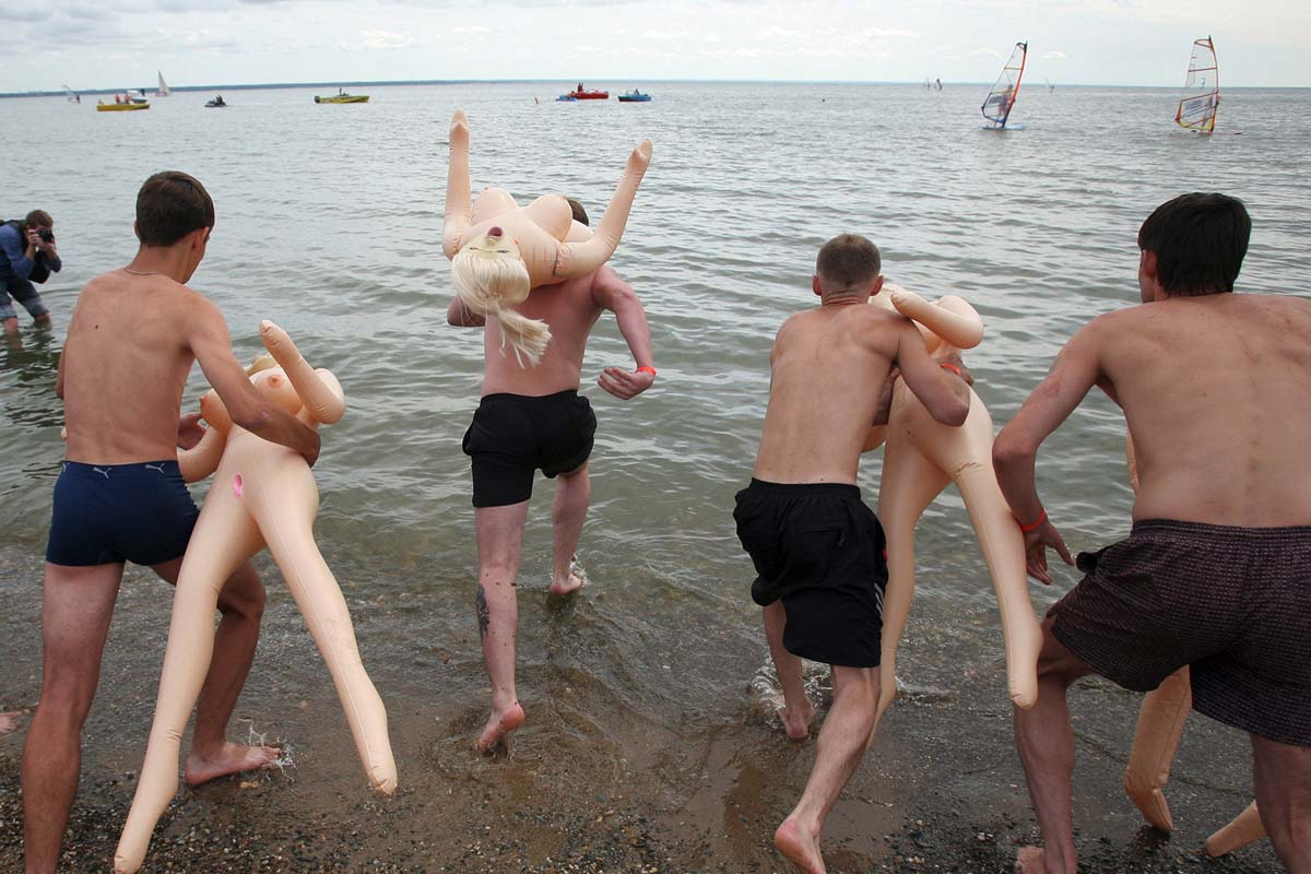 Varios bañistas con muñecas hinchables. (Foto: AFP)