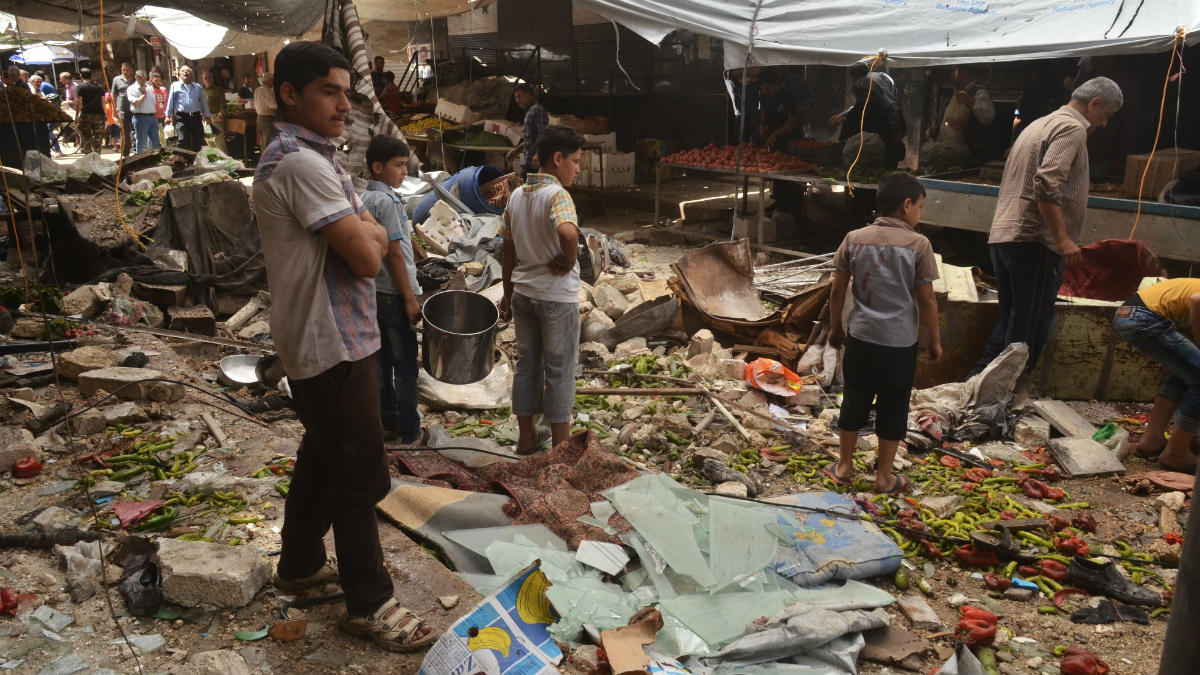 Vecinos del barrio de Al Midan, en Alepo, ante los efectos de un bombardeo rebelde. (AFP)