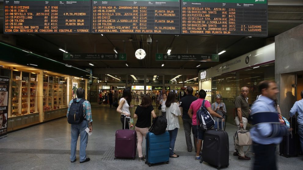 Viajeros miran los horarios en la estación madrileña de Atocha. (Foto: EFE)