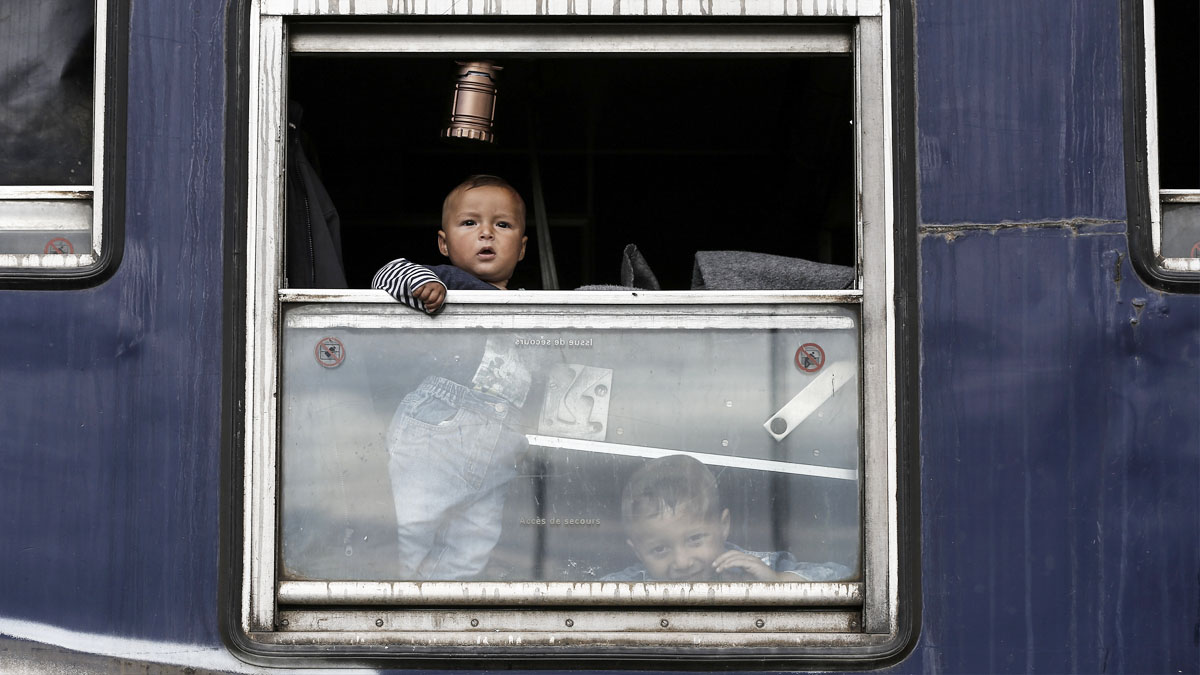 Un niño contempla desde una ventana cómo las autoridades desmontan un campamento próximo a Idomeni. (Foto: AFP)