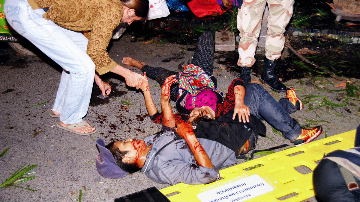 Un grupo de personas ayuda a dos heridos por una de las explosiones. (Foto: AFP)