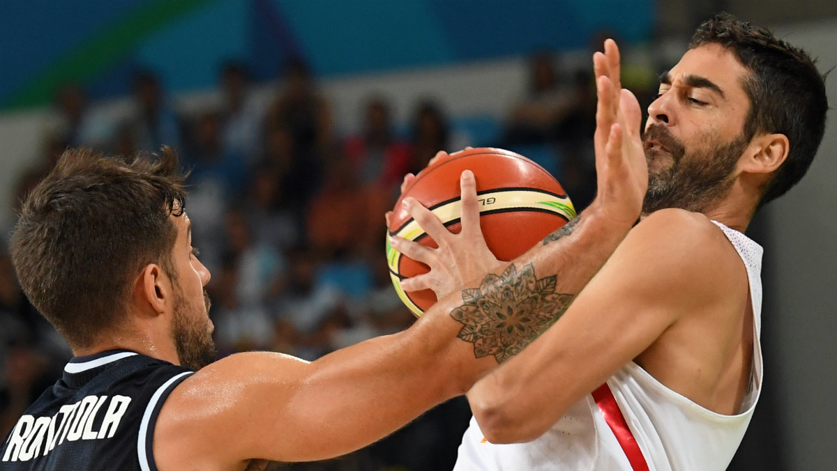 Juan Carlos Navarro recibe un manotazo de un argentino en un partido de baloncesto de estos Juegos. (AFP)