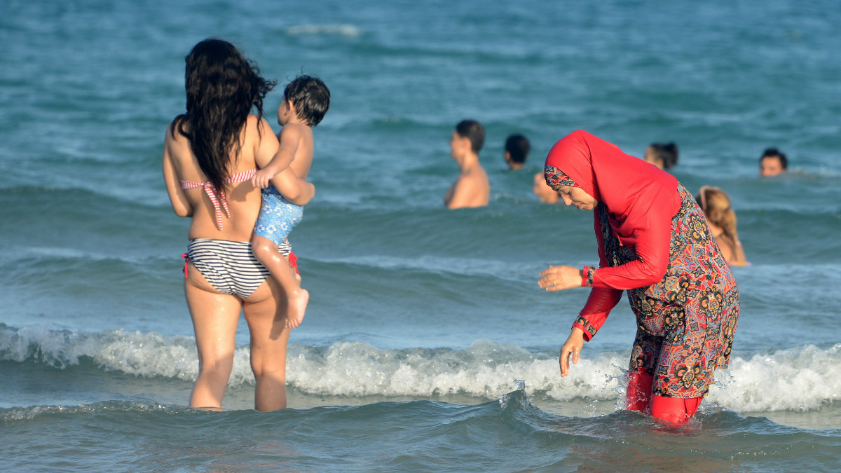 Una mujer musulmana se baña vestida con el polémico burkini, o traje de baño que respeta las leyes del pudor impuestas por el Islam. (Foto: AFP)
