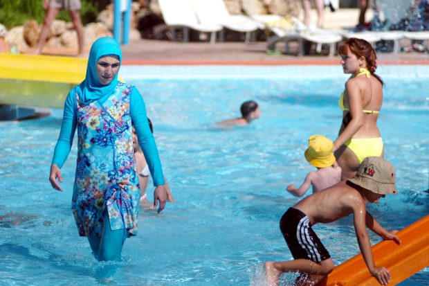 Una mujer se baña en una piscina llevando el polémico 'burkini' que ha sido prohibido en muchas playas de Francia. 